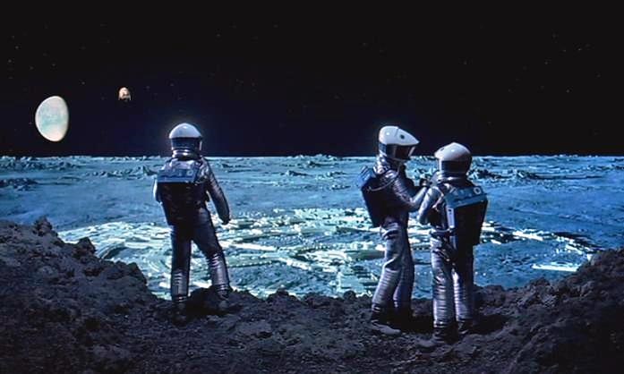 Image from 2001. Several astronauts in space suits inspect a monolith on the Moon